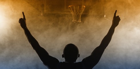 Naklejka premium Rear view of a basketball player with his arms in the air