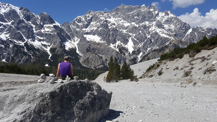 Naklejka premium Woman trekker sitting on the rock looking to the Beautiful rockf