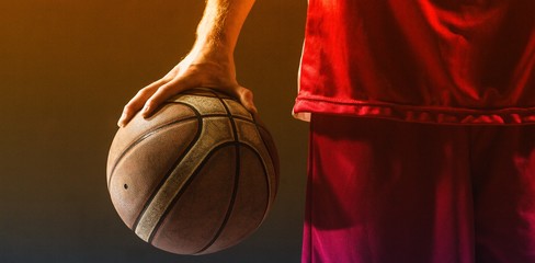 Close up on a basketball held by basketball player