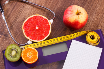 Electronic bathroom scale, centimeter and fresh fruits with stethoscope, slimming and healthy lifestyles