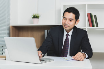 Fototapeta na wymiar Handsome Asian businessman using laptop computer
