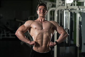 Fototapeta na wymiar Athletic Bodybuilder Fitness Model Posing Exercises