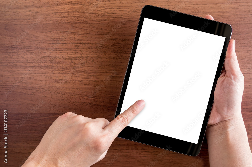 Poster hand touch on empty screen of tablet above brown table top view,