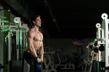 Obraz na płótnie Canvas Muscular Man Exercising With Kettle-bell