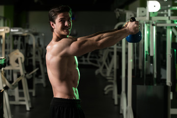 Fitness Man Using Kettlebells Inside Gym