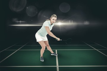Fototapeta na wymiar Composite image of pretty blonde playing badminton 