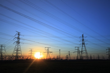 Fototapeta na wymiar The silhouette of the evening electricity transmission pylon