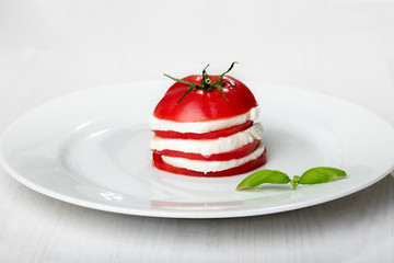 Tomato and mozzarella slices decorated with basil leaves