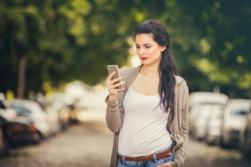 Fototapeta premium Girl using cellphone outdoors.