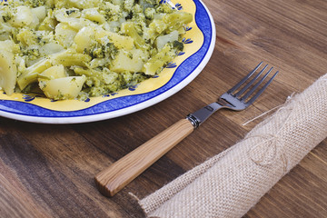 Cauliflower dish with a fork and a napkin on a rustic wooden table. Typical dish of Mediterranean diet