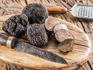 Black truffles on the old wooden table.