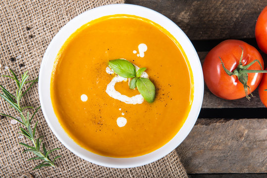 Tomato squash soup with basil leaf and sour cream