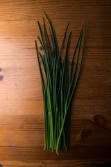 Fresh green chives on wooden board