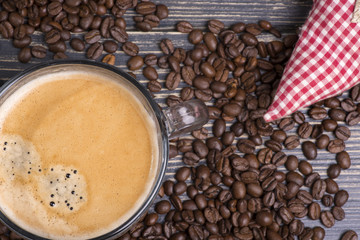 cup of coffee on a wooden table and coffee beans