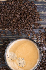 cup of coffee on a wooden table and coffee beans