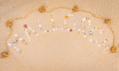 Fototapeta na wymiar Mallorca Schriftzug mit Muscheln und Fischernetz am Sand Strand