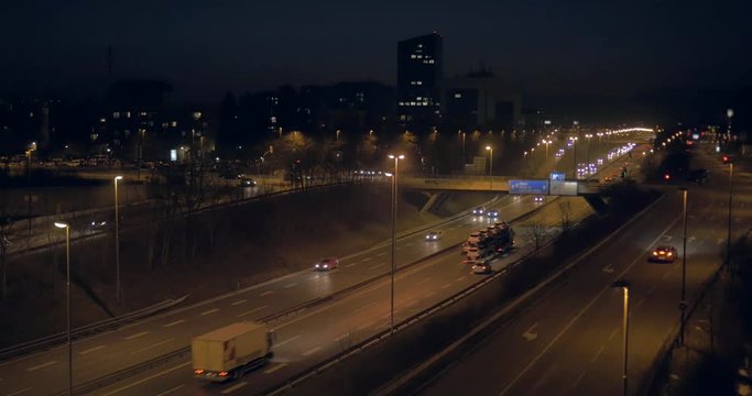 Slow aerial dolly shot just above streets light over city high way at night
