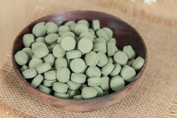Fototapeta na wymiar Herbal pill on wooden bowl. herb for healthy living.