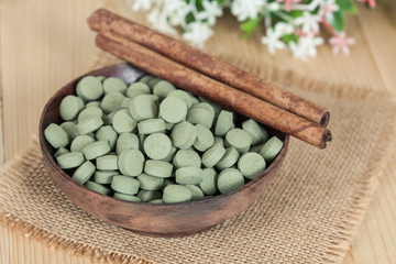 Herbal pill on wooden bowl. herb for healthy living.