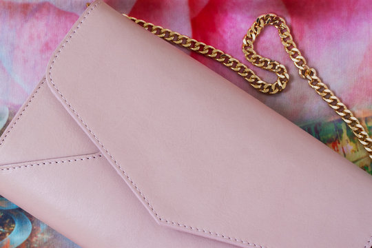Pink envelope purse with gold chain close-up