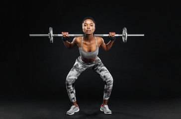 Close-up portrait of fitness girl doing squats with barbell