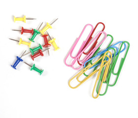 Multicolored paperclips and pin pisolated on white background