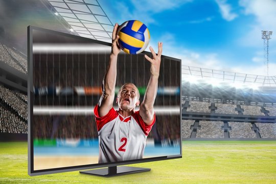Composite image of sportsman catching a volleyball while playing