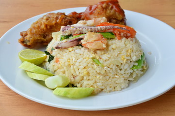 fried rice with mixed seafood and crispy chicken on plate