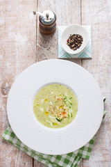 .Zucchini vegetable creamy soup puree in a bowl on a wooden background, top view.