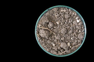 Dry soil in petri dish isolated on black background