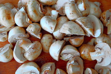White raw champignon closeup on a wooden table. Above view of  group  mushrooms