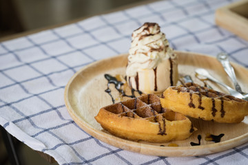 Waffles with chocolate sauce, ice cream and whip cream..