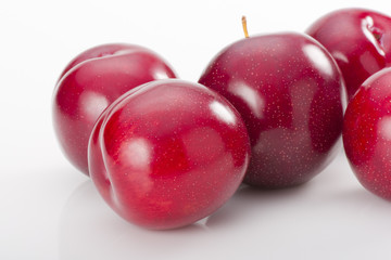 Red plums on white background
