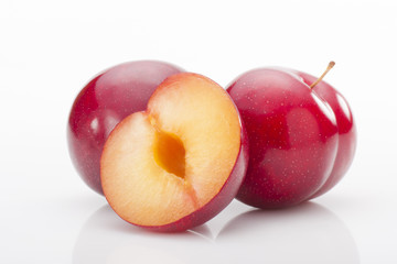 Red plums on white background