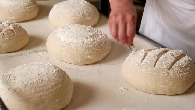 Baker making traditional pattern on the raw ball dough bread