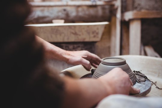 Cropped image of craftsperson making ceramic container