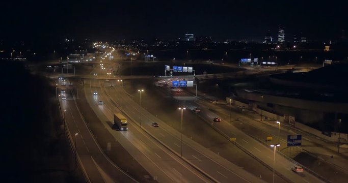 Total aerial view over O ring intersection with cityscape at night
