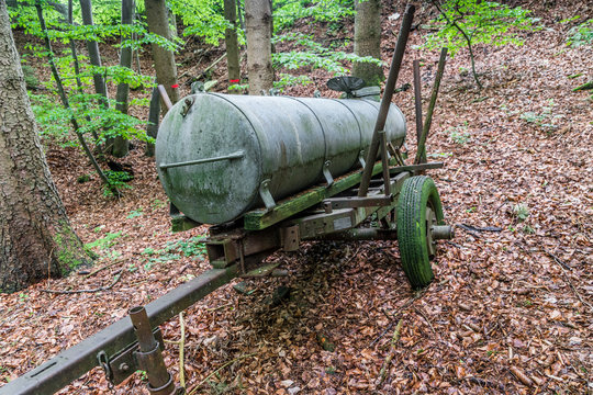 Alter G&uuml;llewagen rostet verlassen im Wald vor sich hin