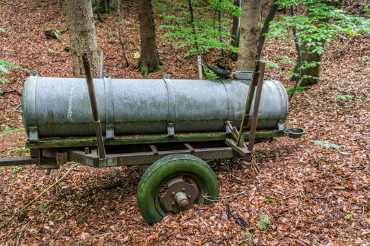 Alter G&uuml;llewagen im Wald mit Moos an den Reifen