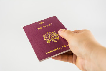 Hand with a passport of a citizen of Moldova on a white background