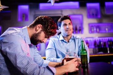 Depressed man having beer at bar counter