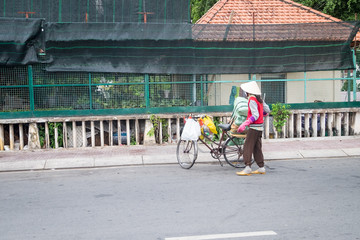 Obraz premium Ho Chi Minh, Vietnam - June 11, 2016: Woman worker collecting cartons for recycling in street city.