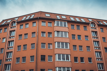 Fototapeta na wymiar orange apartment building in a low angle view