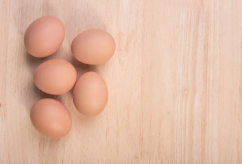 Fresh eggs ingredient on a wooden table rustic background.