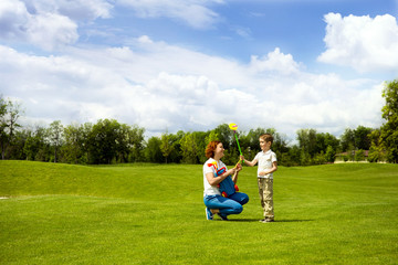 Mother teaching son to play golf