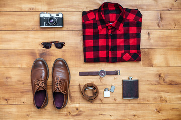 Travel concept shirt, camera, shoes, flask, watch, shoes on desk