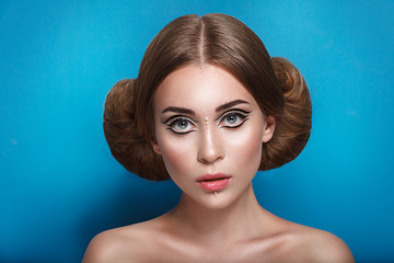 Attractive mysterious young woman with double hair bun in Princess Leia hairstyle looks towards the...