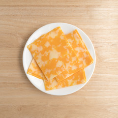 Colby-Jack cheese slices on a plate atop table top view.