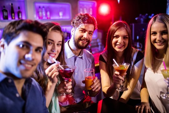 Group of friends having cocktail at bar counter