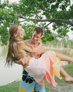Man carrying girlfriend outdoors